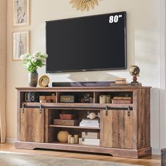 a large flat screen tv mounted to the side of a wooden entertainment center in a living room