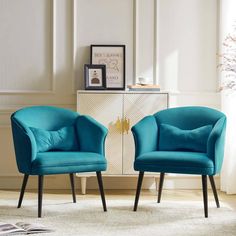 two blue chairs sitting next to each other on top of a white carpeted floor