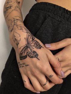 a woman's hand with a butterfly tattoo on it, and her left wrist