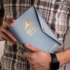 a man is holding a blue case with the word alaska on it and gold lettering