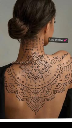 the back of a woman's neck is covered with hennap and tattoos