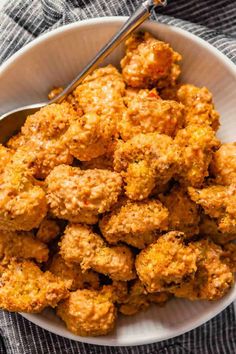 a white bowl filled with tater tots on top of a checkered table cloth