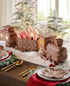 a table set for christmas with gingerbreads, candy canes and other holiday treats