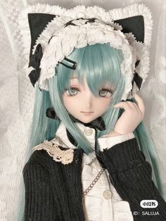 a doll with blue hair wearing a black and white outfit