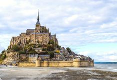 an old castle sits on top of a rock outcropping