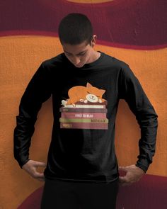 a man standing in front of a wall wearing a black shirt with an orange cat on it