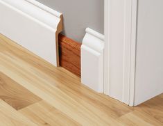 the corner of a room with wood flooring and white trim