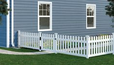 a white picket fence in front of a blue house