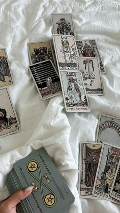 the tarot cards have been placed next to each other on a white bed sheet