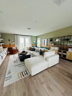 a living room filled with furniture and lots of windows