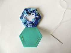 an ornament made out of fabric with scissors next to it on a white surface