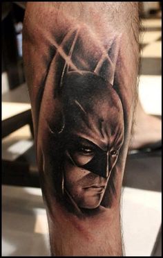 a man's leg with a batman tattoo on it