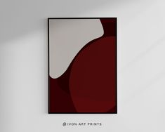 a red and white painting hanging on the wall next to a black framed art piece