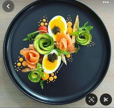 a black plate topped with eggs and vegetables