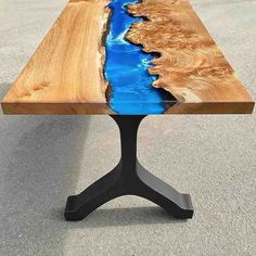 a wooden table with blue water in the center and black metal legs on each side