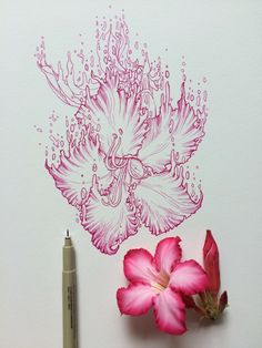 a pink flower sitting on top of a white paper next to a marker and pen