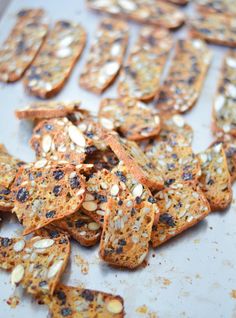 some kind of crackers that are on a tray with nuts and seeds all over them