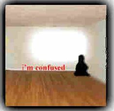 a blurry image of a person sitting on the floor with an i'm confused sign in the background