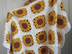 a crocheted blanket with sunflowers on it