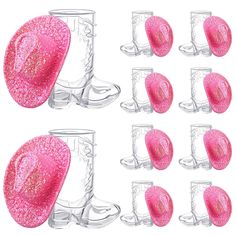 six pairs of pink glittered boots and one pair of clear glass cups are shown