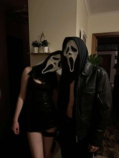 two people dressed up in costumes with masks on their faces and mouths, standing next to each other