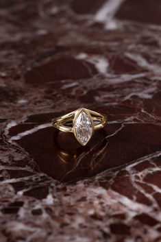 a diamond ring sitting on top of a marble surface