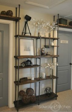 a room with some shelves and pictures on the wall above them, in front of a door