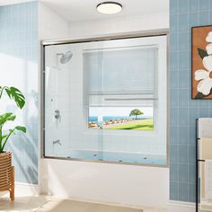 a bathroom with blue tile walls and white tiles on the floor, along with a large window