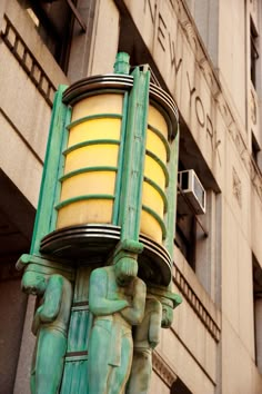 a green and yellow lamp on the side of a building