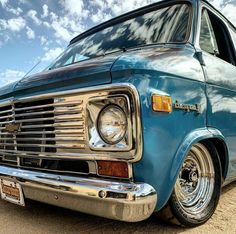 an old blue van is parked in the dirt