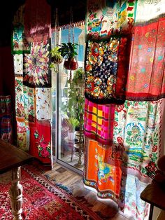 a room filled with lots of colorful rugs and windows covered in different colored fabrics