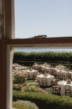 tables and chairs are set up for an outdoor wedding reception by the water's edge