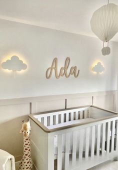 a baby's room with a crib, lamp and teddy bear in it