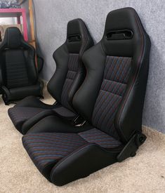 two black and blue seats sitting next to each other in a room with carpeted flooring