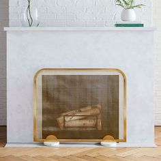 a fireplace with a painting on the mantle and some plants in vases next to it