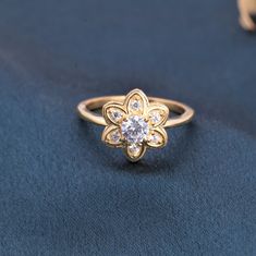 a diamond ring sitting on top of a blue cloth