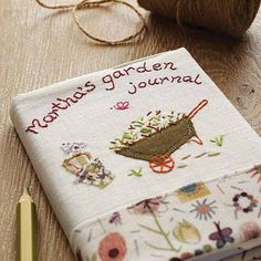 there is a small book on the table next to some knitting needles and yarns