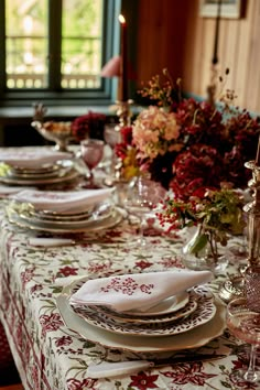 a table set with place settings and flowers