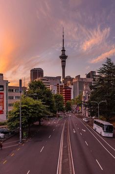 a city street with cars and buses on it at sunset or dawn in the middle of the day