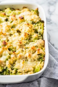 a casserole dish with broccoli and chicken in it on a towel