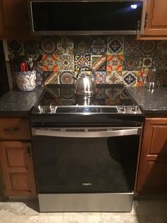 a stove top oven sitting inside of a kitchen next to wooden cabinets and counter tops