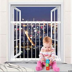 a baby sitting in front of a window with bars on it's sides and holding a toy