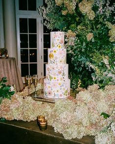 a wedding cake sitting on top of a table covered in flowers