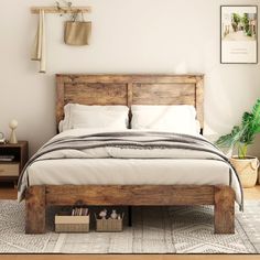 a bed with white linens and wooden headboard in a small room next to a potted plant