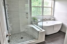 a white bath tub sitting next to a walk in shower