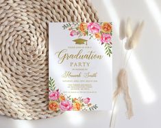 a graduation party card with flowers on it next to a straw hat and some feathers