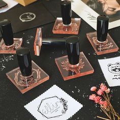 some black and red ink pens sitting on top of a table next to other items