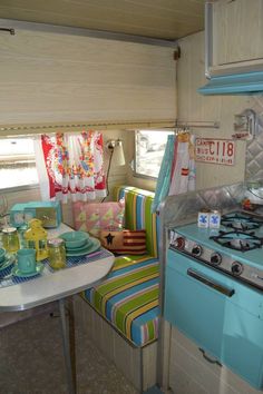 a kitchen area with a stove top oven and table in it, next to a window