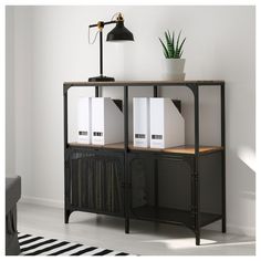 a black metal bookcase with three books on top and two white file cabinets below