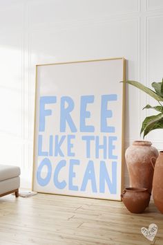 a blue and white poster that says free like the ocean next to two vases